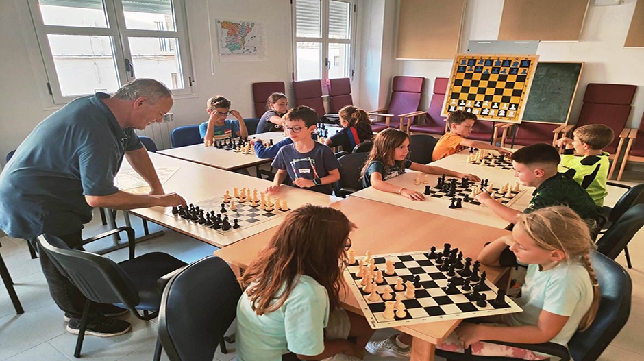 Fernando Lasheras, profesor de la escuela de ajedrez de Alcubierre y un grupo de alumnos en una de sus clases.
