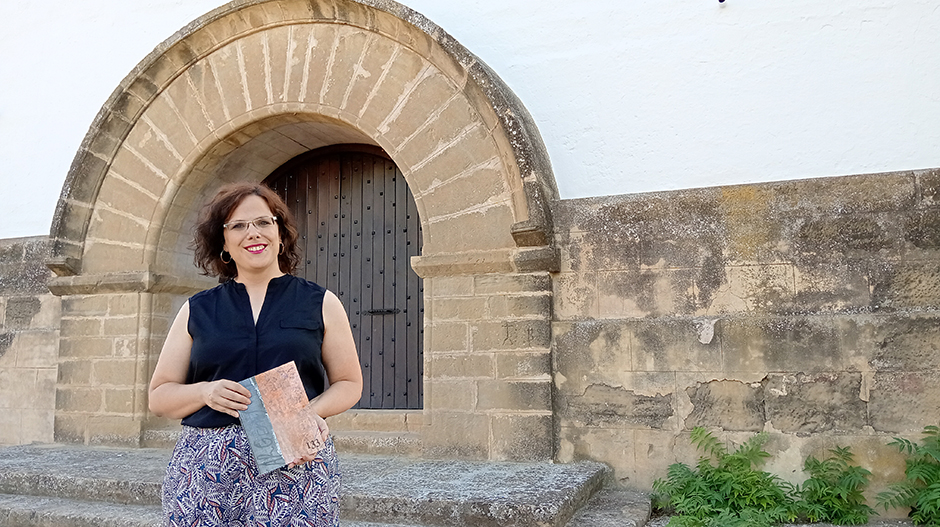 Gemma Grau, con la publicación de su investigación, junto a la ermita de Santiago de Sariñena.